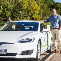 Jake Whitehead beside electric vehicle